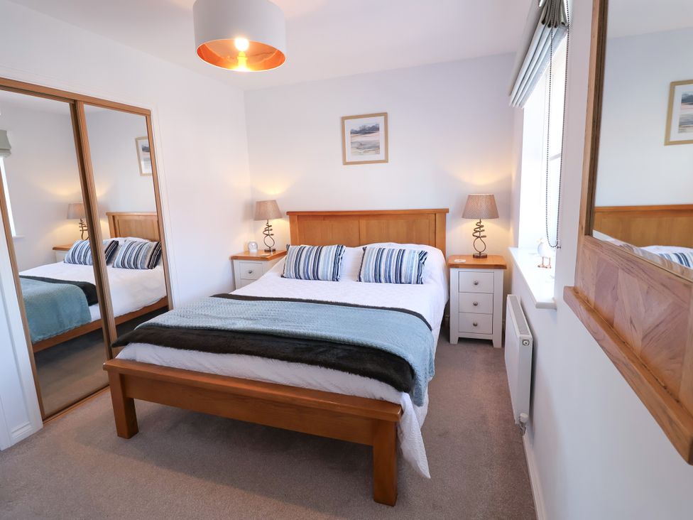 A bedroom with a bed and bedside tables at Lapwings, Aldeburgh
