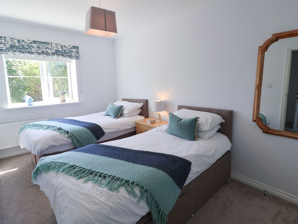 A bedroom with two beds and a window at Lapwings, Aldeburgh