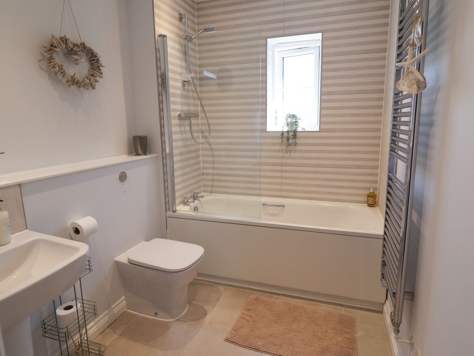 A bathroom with a bath tub and shower at Lapwings, Aldeburgh