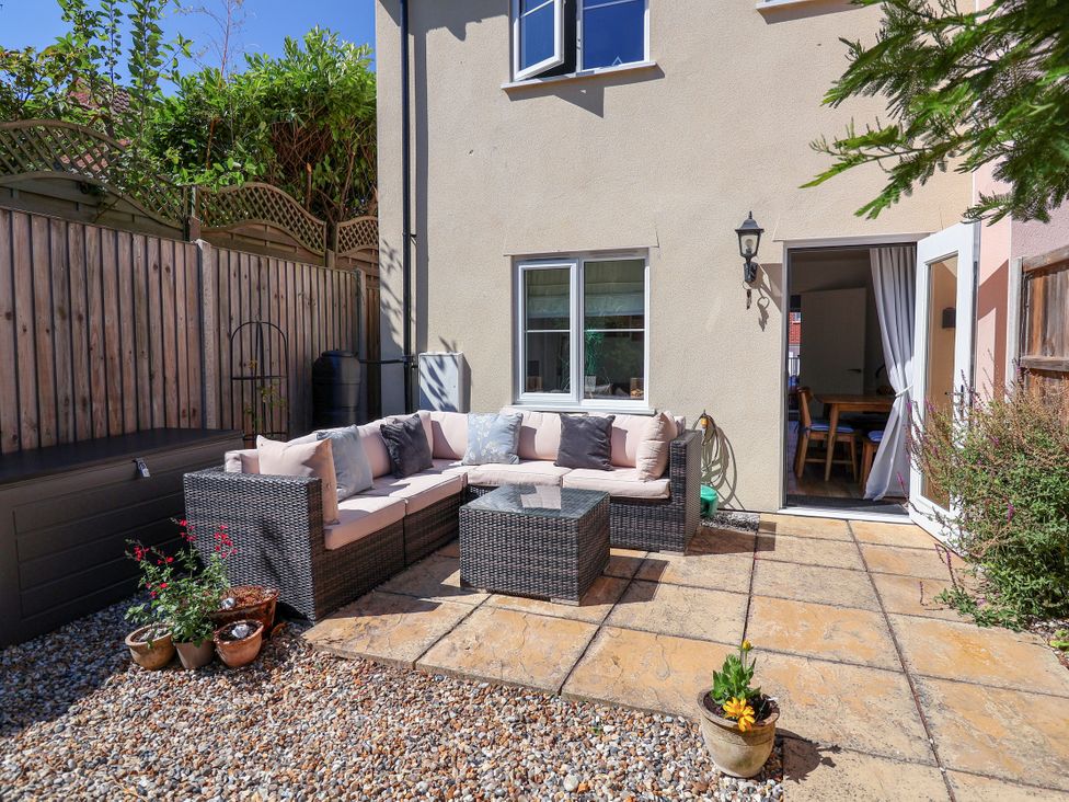 An outdoor seating area with a sofa and coffee table at Lapwings, Aldeburgh