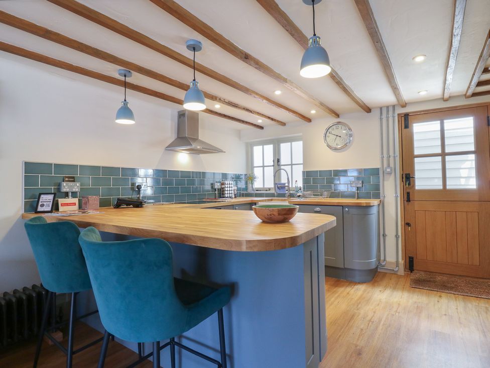 A kitchen with a sink and bar stools at The Annex Cavendish Near Sudbury