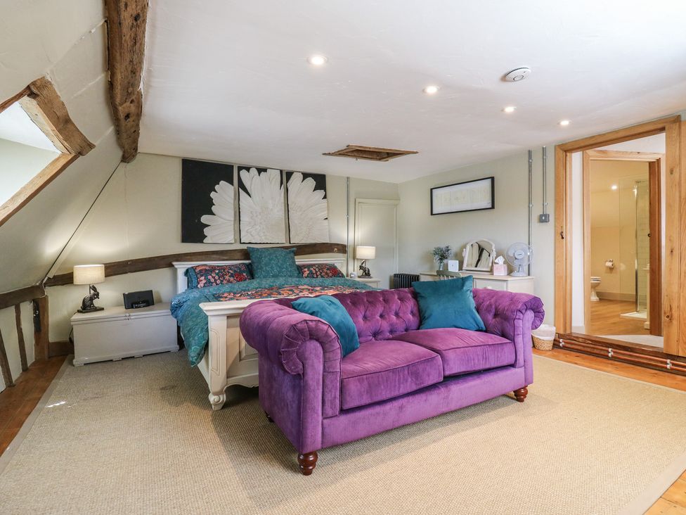 A bedroom with bed and sofa at The Annex in Cavendish Near Sudbury