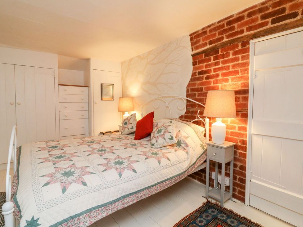 A bedroom with a bed and wardrobe at Whitefield Cottage in Barnstaple
