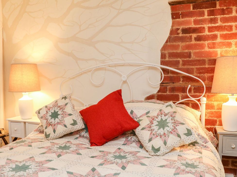 A bedroom with a bed and lamp at Whitefield Cottage in Barnstaple
