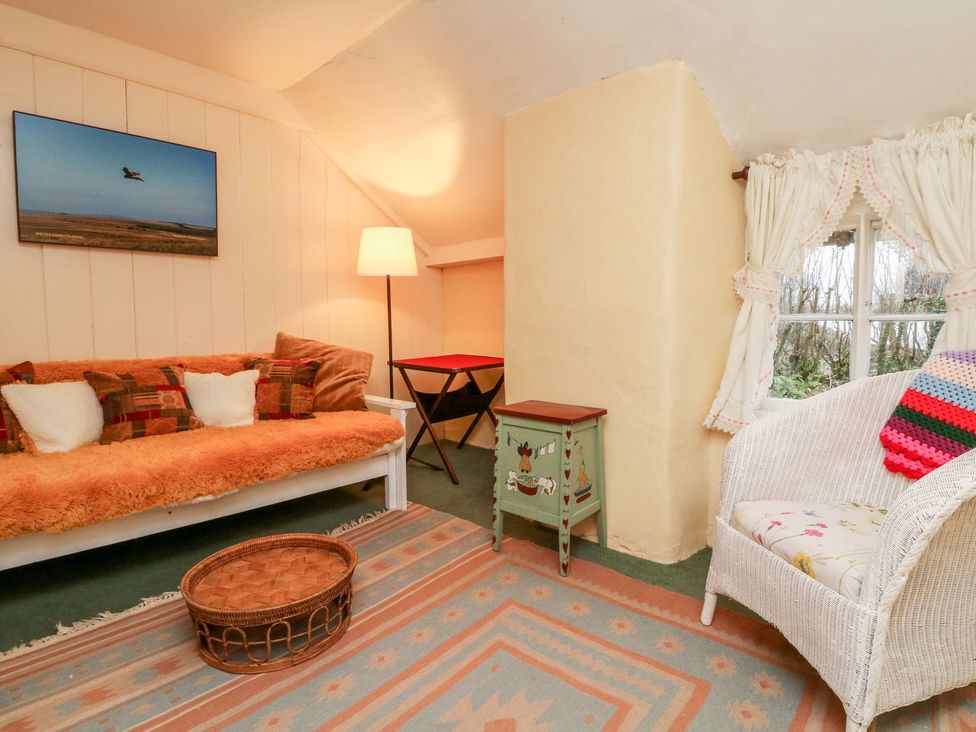 A snug area with a sofa and lamp at Whitefield Cottage in Barnstaple