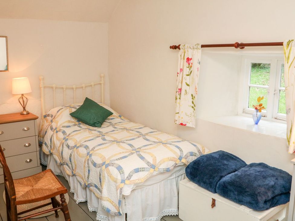 A bedroom with a bed and a window at Whitefield Cottage in Barnstaple