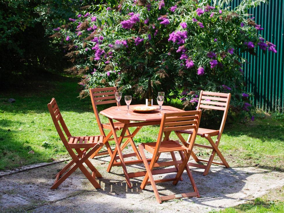 A table with chairs and glasses in a garden at Whitefield Cottage in Barnstaple