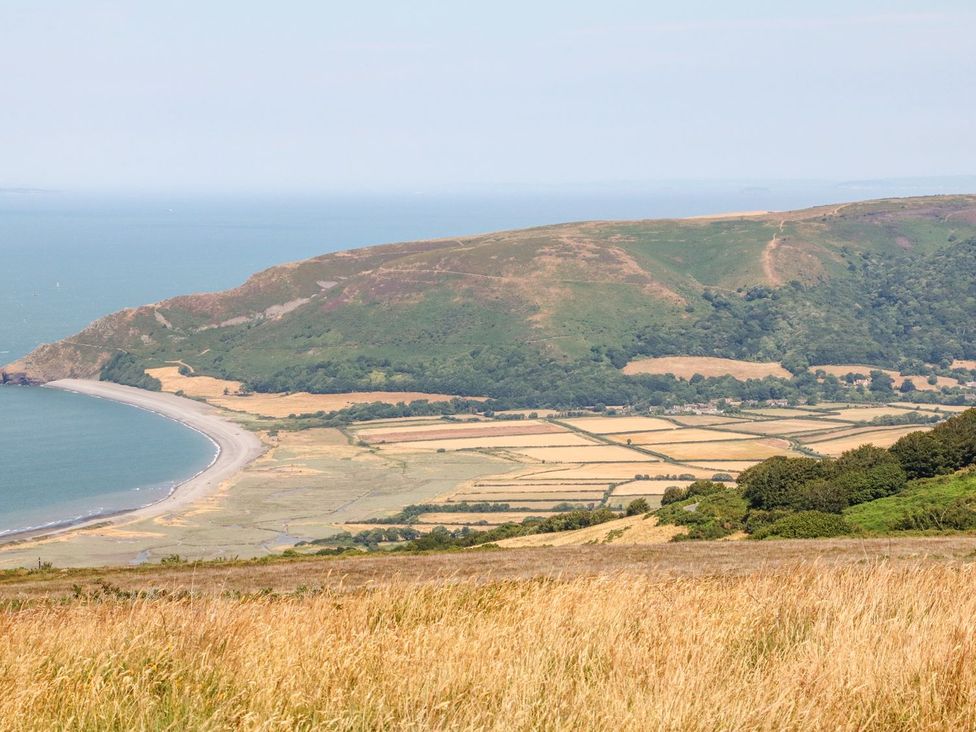 A coastal landscape with a beach and hills at Whitefield Cottage in Barnstaple