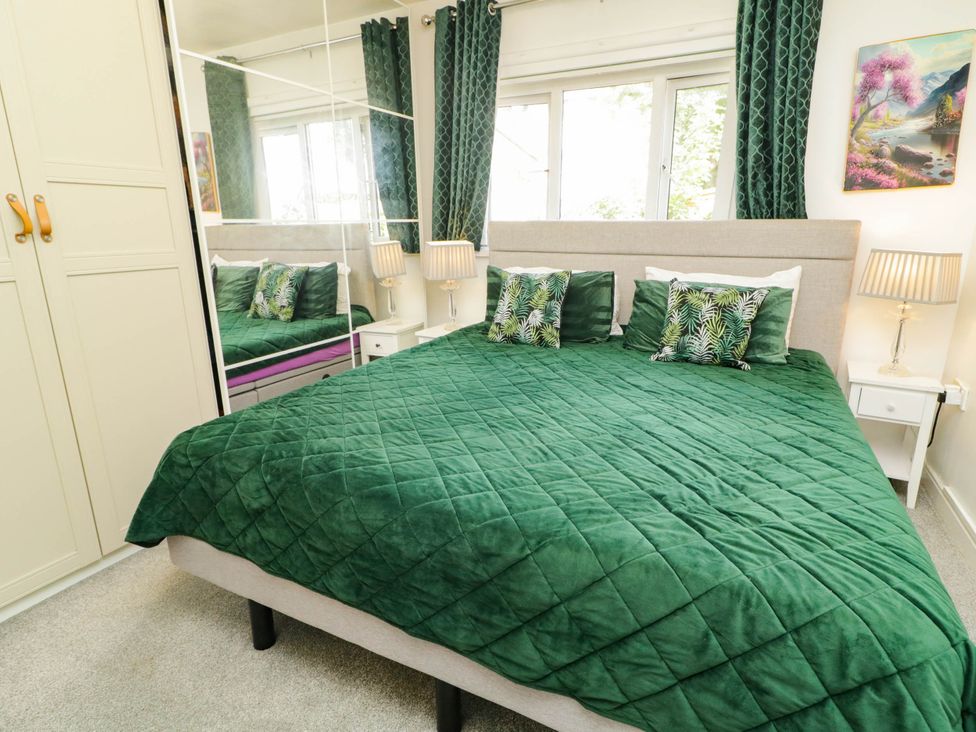 A bedroom with a green bedspread and pillows at 59 Nursery Avenue, Coleraine