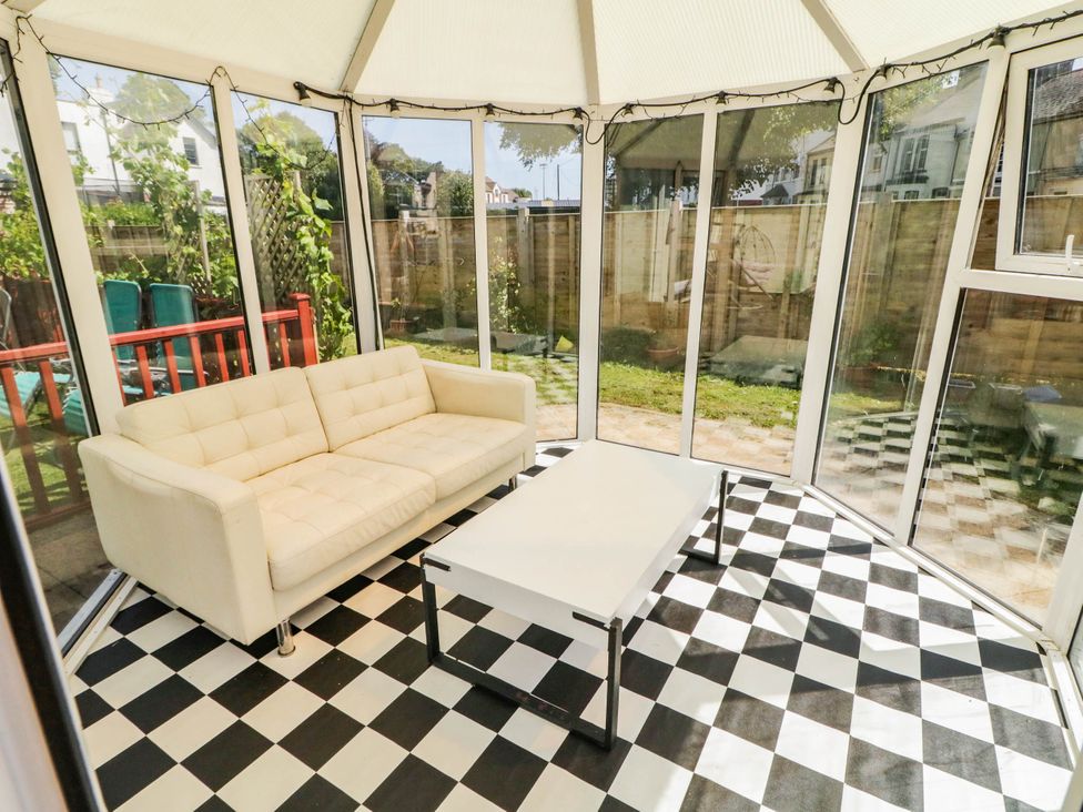 A conservatory with a sofa and a coffee table at 59 Nursery Avenue in Coleraine