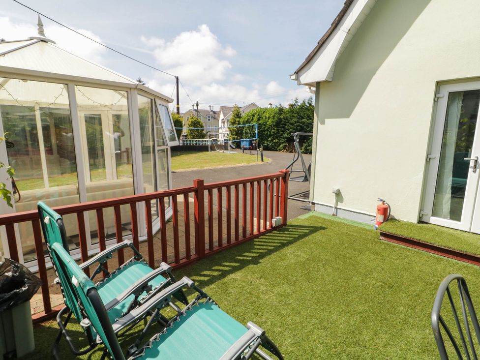 An outdoor space with chairs and a conservatory at 59 Nursery Avenue Coleraine