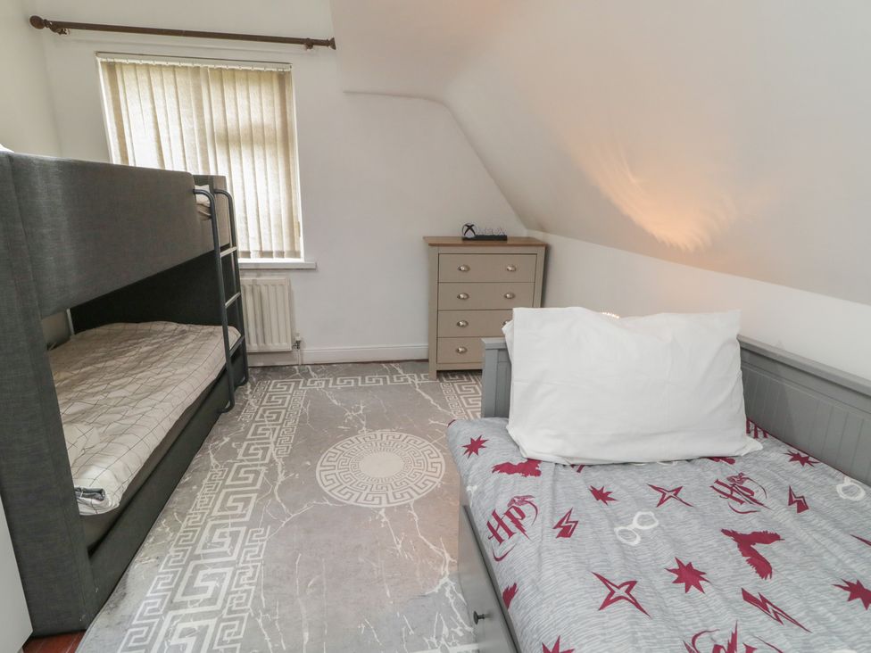 A bedroom with a bunk bed and a single bed at 59 Nursery Avenue, Coleraine