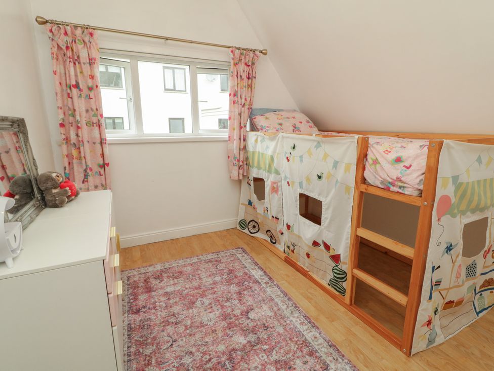 A bedroom with a loft bed, curtains, and a mirror at 59 Nursery Avenue in Coleraine
