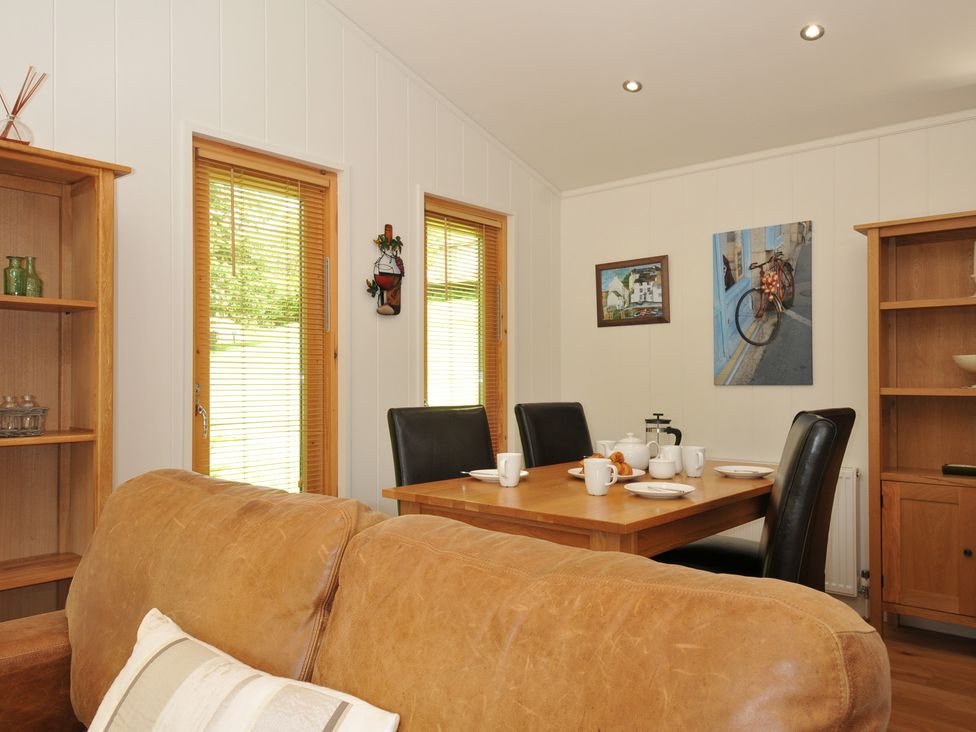 A dining room with a table and chairs at 11 Water's Edge near Pelynt
