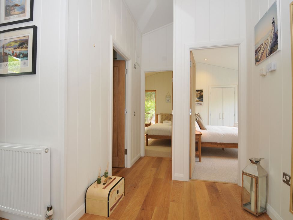 A hallway with paintings and a radiator at 11 Water's Edge near Pelynt