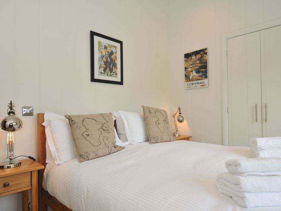 A bedroom with a bed and decorative pillows at 11 Water's Edge near Pelynt
