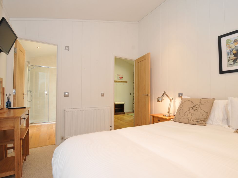 A bedroom with a bed and television at 11 Water's Edge near Pelynt