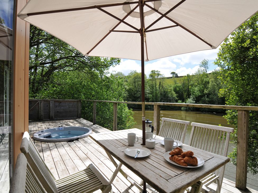 An outdoor terrace with a table and chairs at 11 Water's Edge near Pelynt