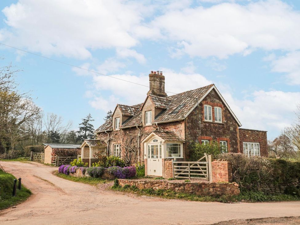 A house with a pathway and flowers at Tuxwell Lodge in Bridgwater