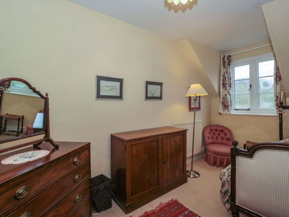 A bedroom with a dresser and an armchair at Tuxwell Lodge in Bridgwater