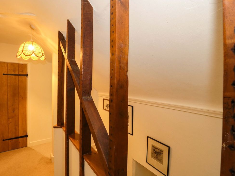 A staircase with a wooden door and wall art at Tuxwell Lodge in Bridgwater