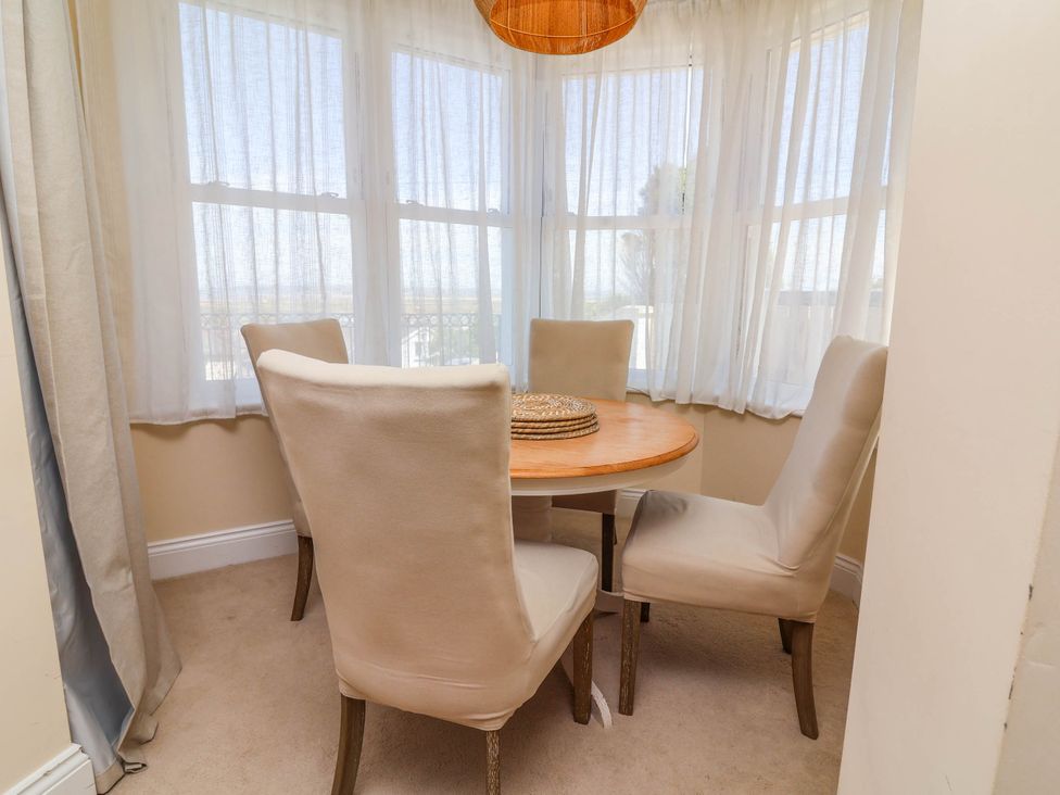 A dining room with a round table and four chairs at Sea Vista Westward Ho!