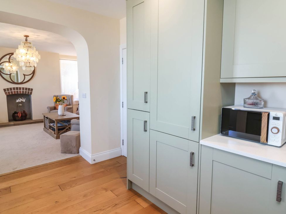 A kitchen with cabinets and a microwave at Sea Vista in Westward Ho!