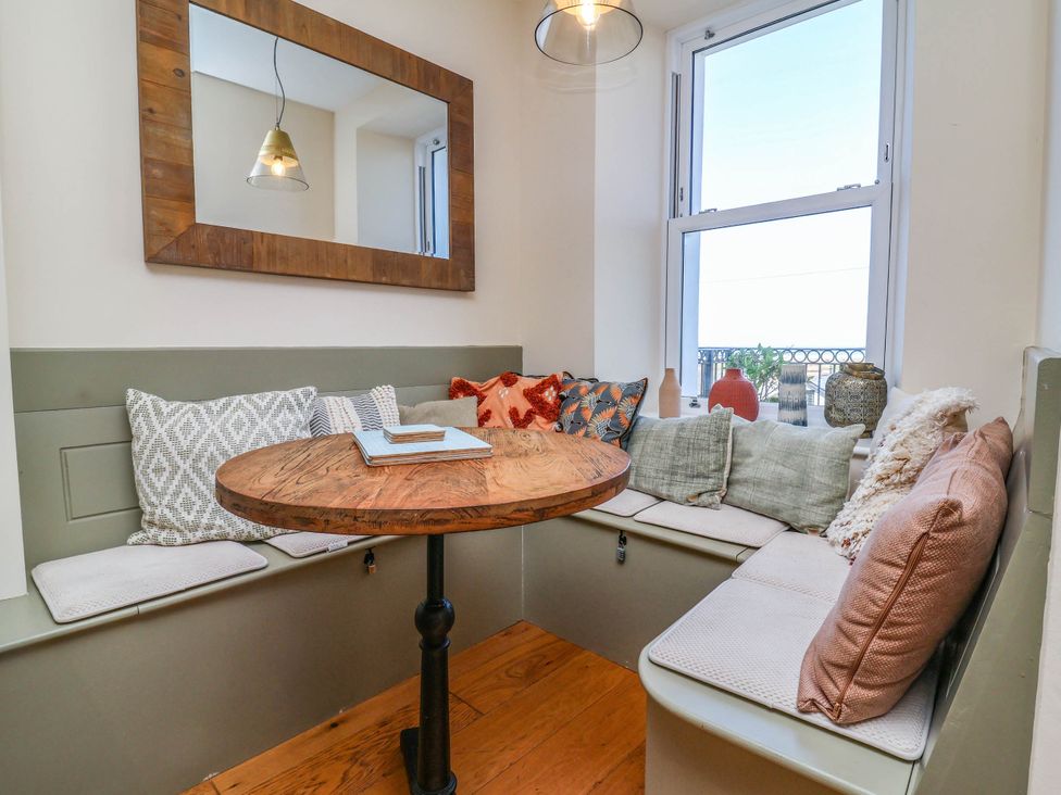 A dining nook with a round table and cushioned seating at Sea Vista in Westward Ho!