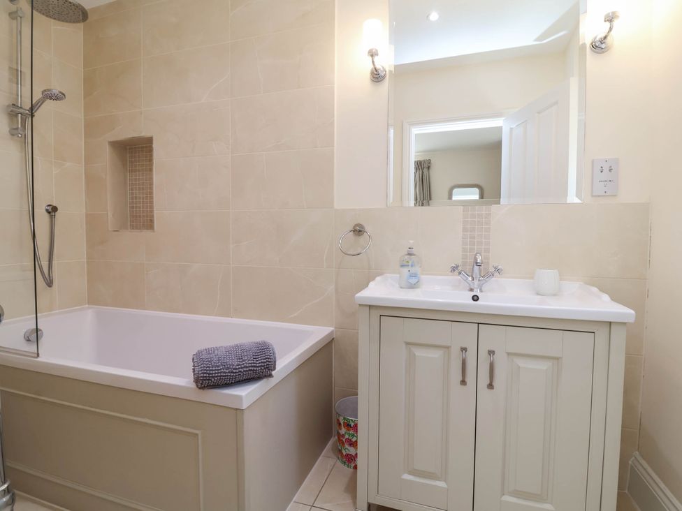 A bathroom with a bathtub, sink, and shower at Sea Vista in Westward Ho!
