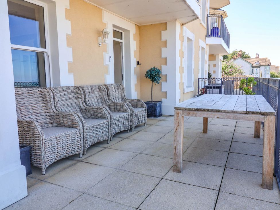 An outdoor seating area with a table and chairs at Sea Vista in Westward Ho!