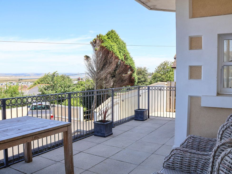 An outdoor terrace with a table and chairs at Sea Vista in Westward Ho!