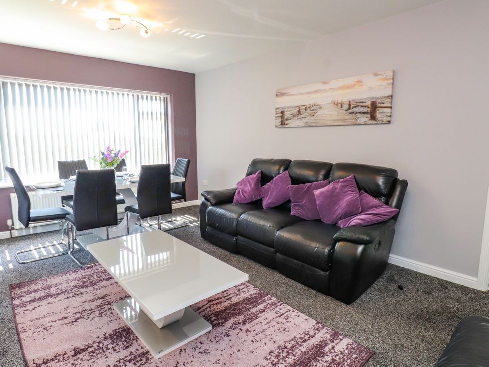 A living room with a sofa and dining area at Ger y Mynydd, 2 Cae Ty Coch, Brynteg
