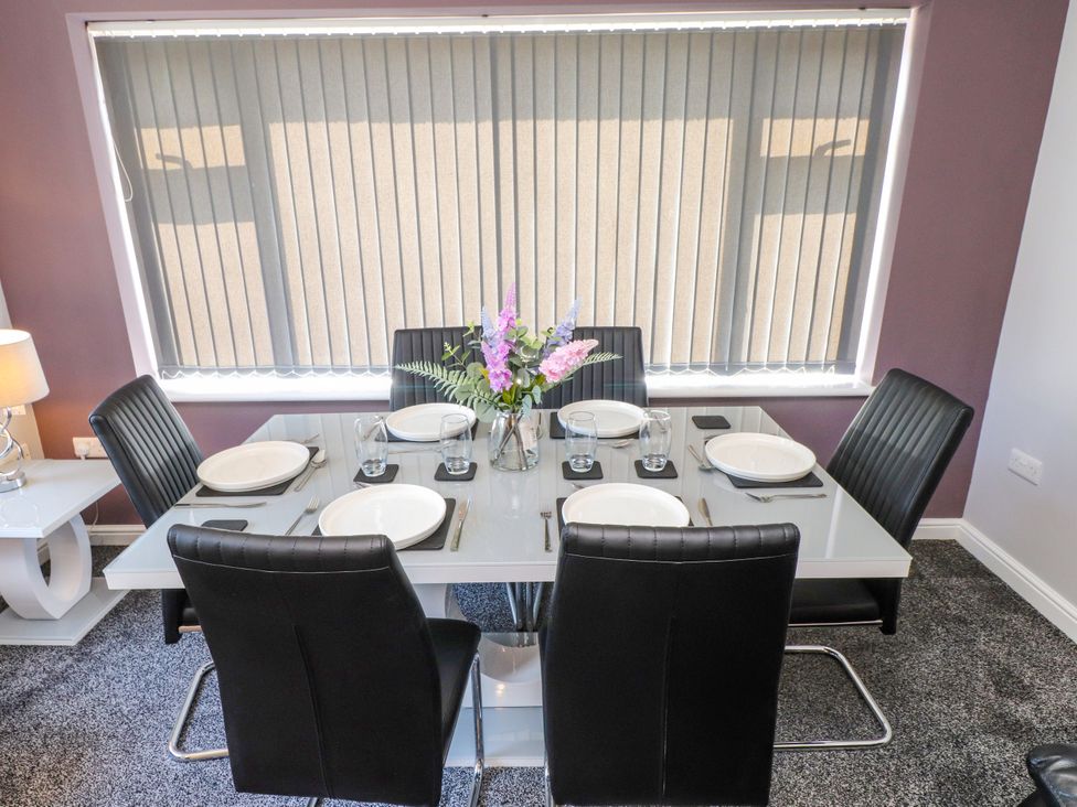 A dining table set with plates and glassware at Ger y Mynydd, 2 Cae  Ty Coch in Brynteg