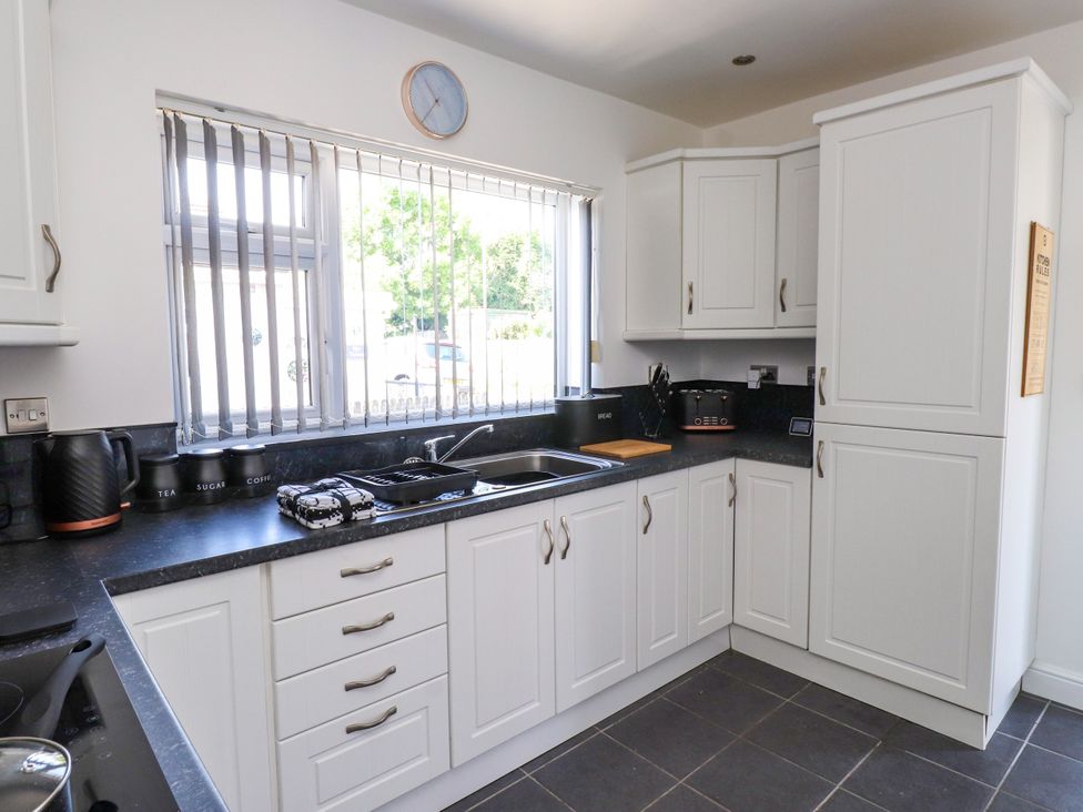 A kitchen with cabinets and a sink at Ger y Mynydd, 2 Cae Ty Coch in Brynteg