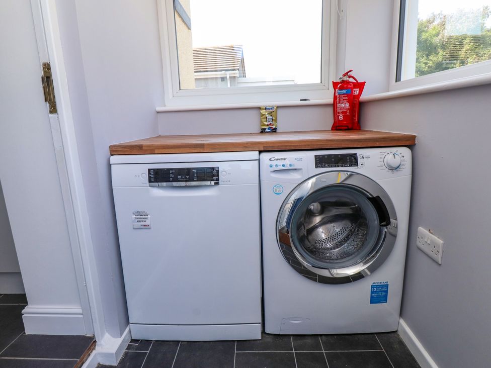A laundry room with a dishwasher and washing machine at Ger y Mynydd, 2 Cae Ty Coch in Brynteg
