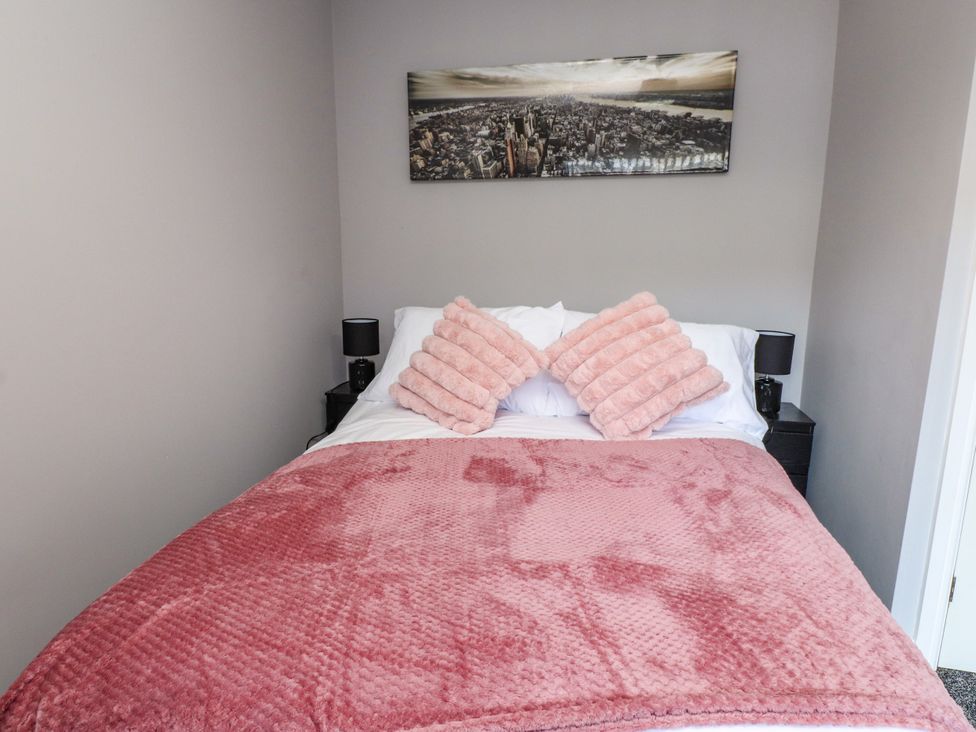 A bedroom with a bed and wall art at Ger y Mynydd, 2 Cae Ty Coch Brynteg