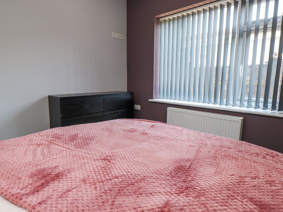 A bedroom with a bed, drawer unit, and window at Ger y Mynydd, 2 Cae Ty Coch, Brynteg