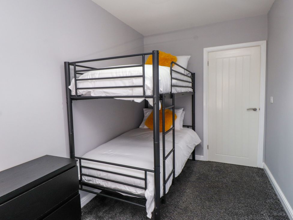 A bedroom with a bunk bed and dresser at Ger y Mynydd, 2 Cae Ty Coch in Brynteg