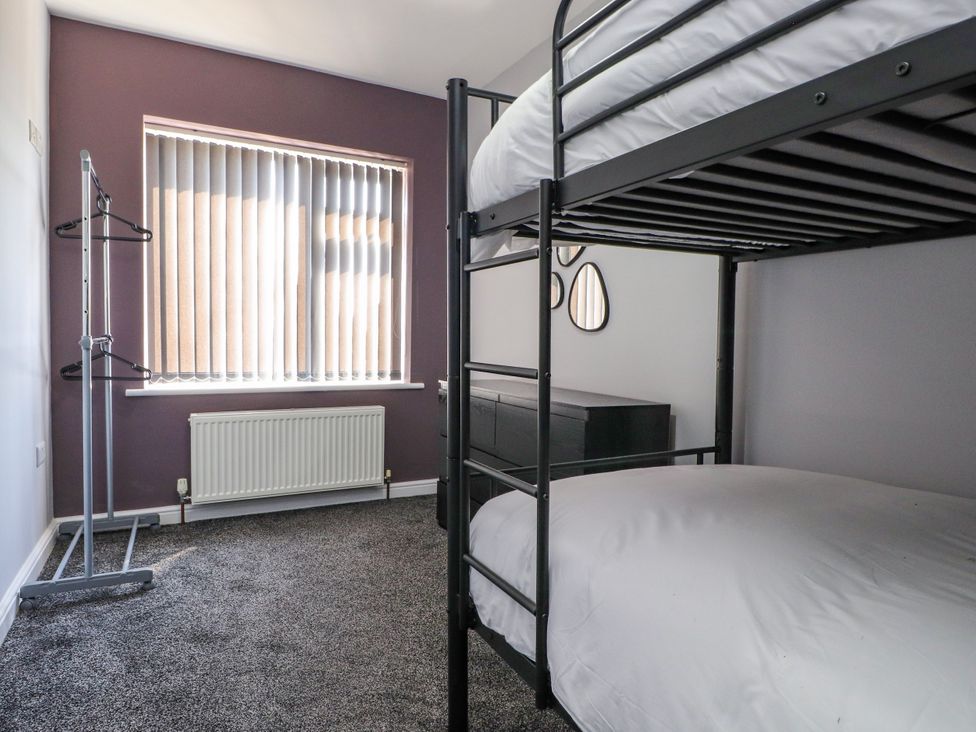 A bedroom with a bunk bed and a dresser at Ger y Mynydd, 2 Cae Ty Coch, Brynteg
