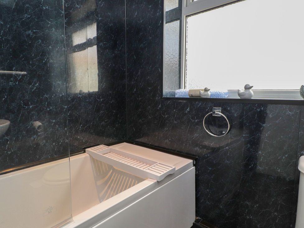 A bathroom with a bathtub and toilet at Ger y Mynydd, 2 Cae Ty Coch, Brynteg