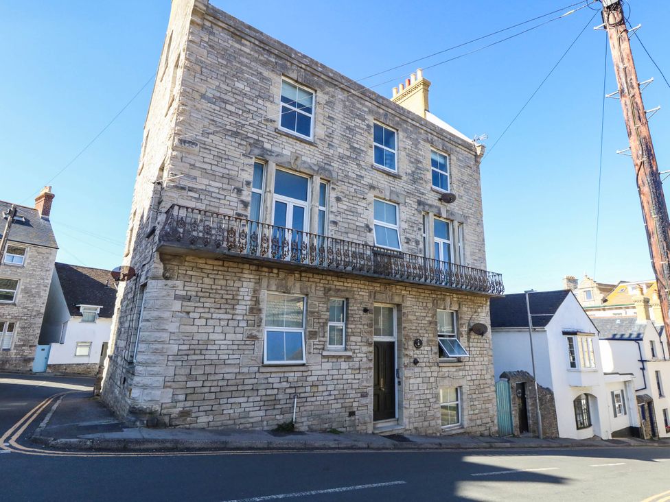 A corner building with a balcony and windows at Flat 3, 4 Park Road Swanage