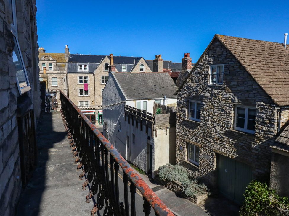 An outdoor view from a balcony showing buildings and a clear blue sky at Flat 3, 4 Park Road in Swanage