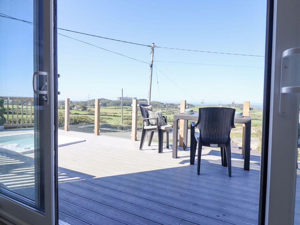 A patio area with an outdoor table and chairs at Posh Pod in Cemaes Bay