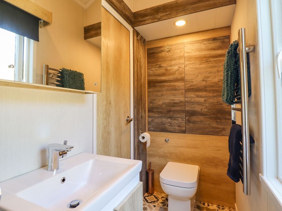 A bathroom with a sink and toilet at Posh Pod in Cemaes Bay