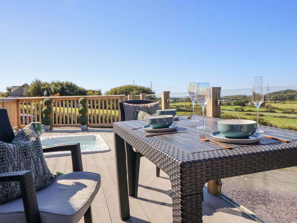 An outdoor dining area with table and chairs at Posh Pod in Cemaes Bay