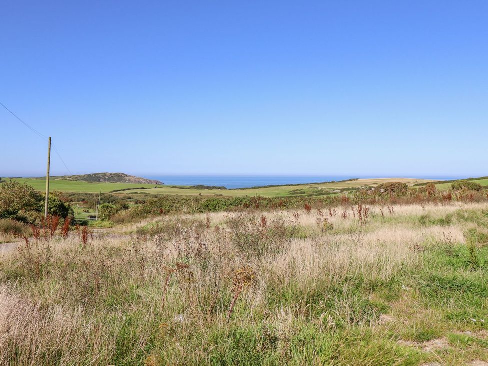A view of grass and sea at Posh Pod in Cemaes Bay