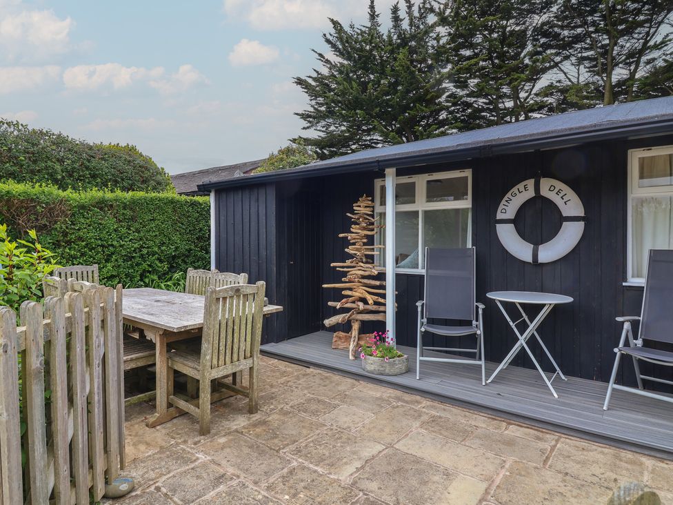 An outdoor seating area with a table and chairs at Dingle Dell in Braunton