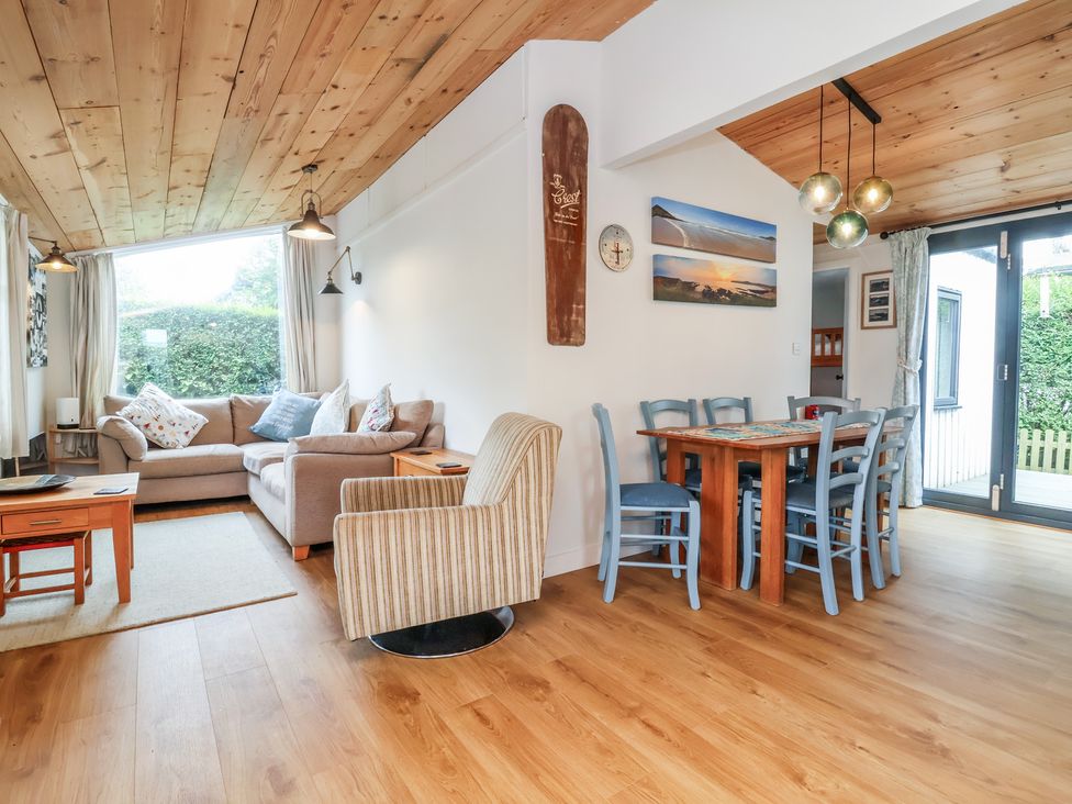 A living room with a sofa and dining area at Dingle Dell in Braunton