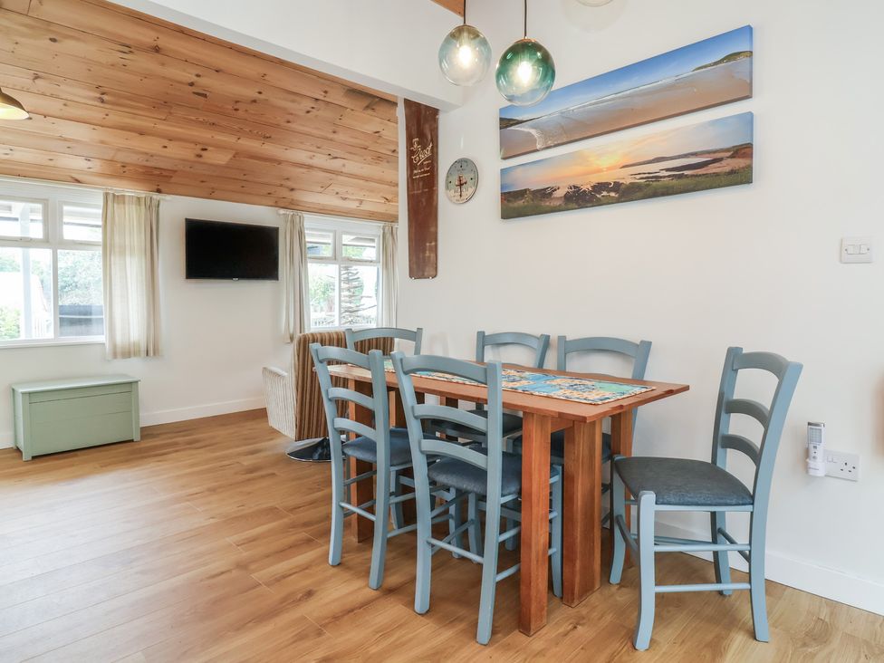A dining room with a table and chairs at Dingle Dell in Braunton
