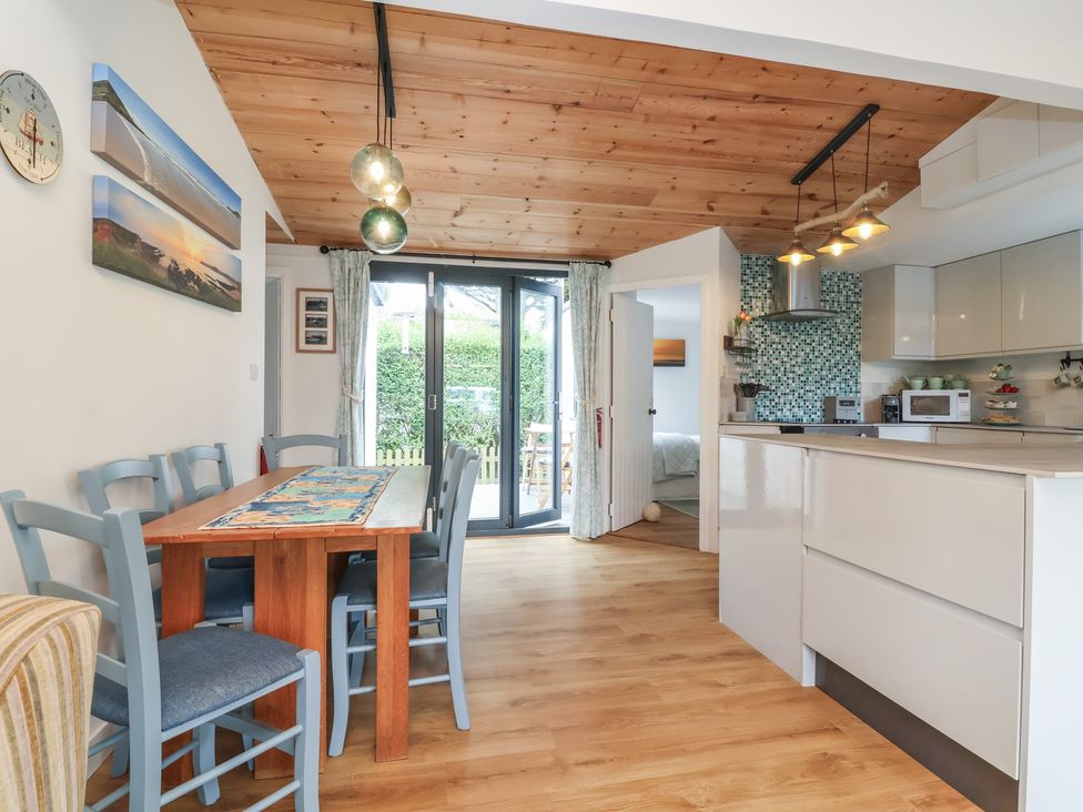 A dining room with a table and chairs at Dingle Dell Braunton